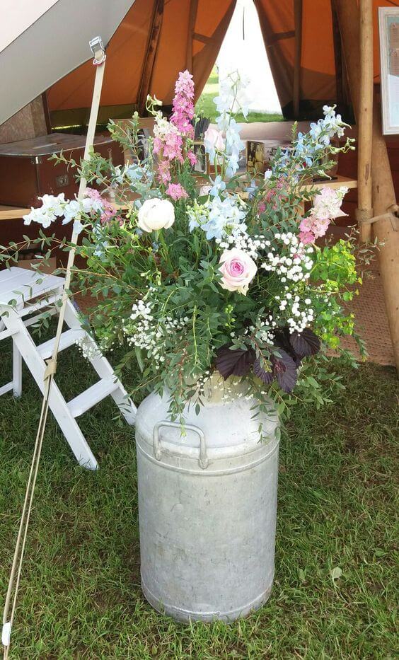 Milk churn in tipi with mix of country flowers